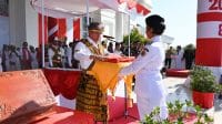 hut ri 1 Bupati Kupang Yosef Lede menyerahkan Bendera Merah Putih kepada petugas pembawa baki dalam upacara pengibaran Bendera Merah Putih ini adalah Ni Made Widya Sriadi Dwi Jayanti, asal SMA Negeri 1 Kupang Timur, Minggu. Foto Prokopim Setda Kabupaten Kupang.