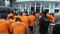 lgbt Polisi menggiring puluhan tersangka yang terjaring gerebekan dalam "LGBT Siwalan Party" menuju ke ruang tahanan di Polrestabes Surabaya, Rabu (22/10/2025). foto ant
