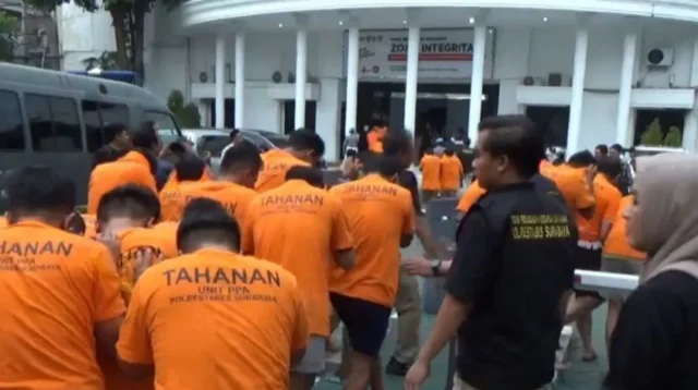 lgbt Polisi menggiring puluhan tersangka yang terjaring gerebekan dalam "LGBT Siwalan Party" menuju ke ruang tahanan di Polrestabes Surabaya, Rabu (22/10/2025). foto ant